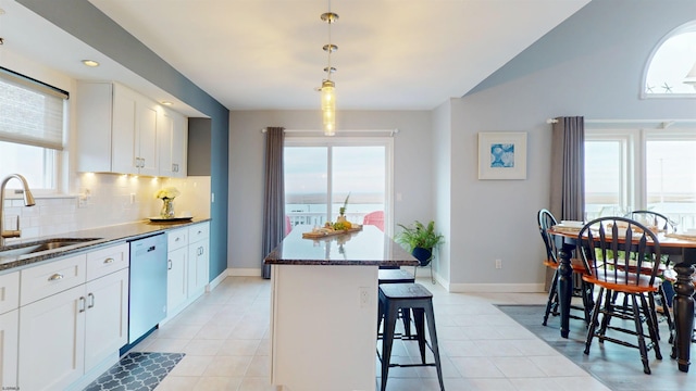 kitchen featuring a center island, white cabinetry, a sink, and stainless steel dishwasher