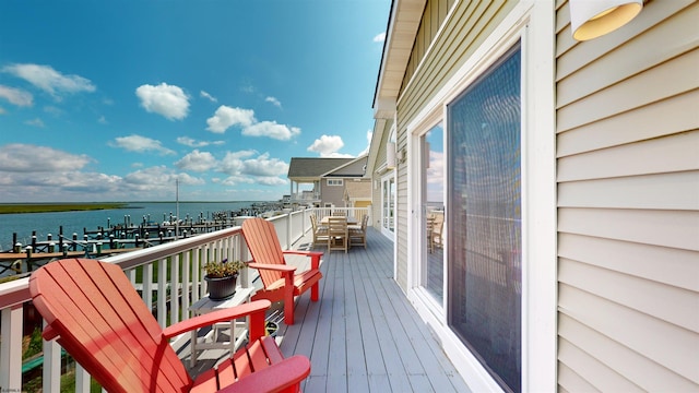 wooden terrace with outdoor dining space and a water view