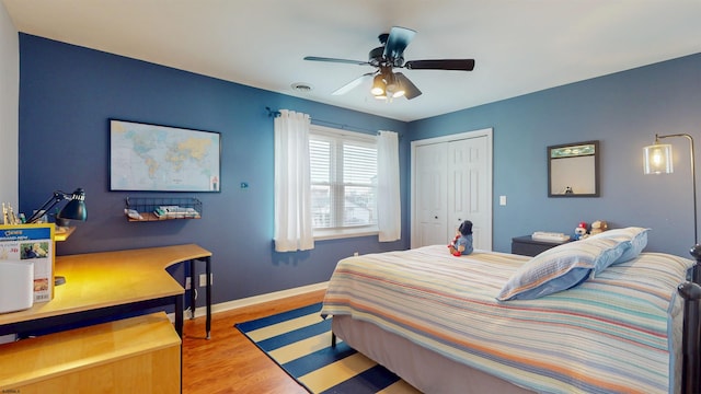 bedroom featuring a closet, visible vents, light wood-style floors, ceiling fan, and baseboards