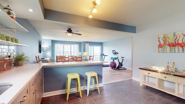 kitchen with a ceiling fan, baseboards, light countertops, open shelves, and beamed ceiling