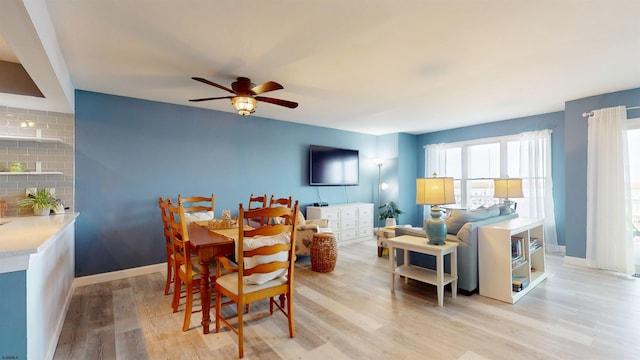 dining space with a ceiling fan, light wood-style flooring, and baseboards