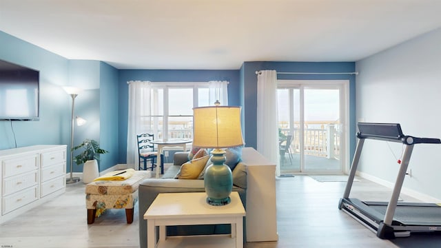 sitting room with baseboards and light wood finished floors