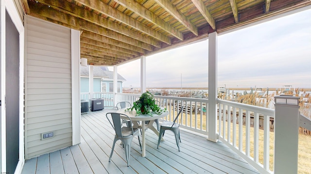 wooden deck with outdoor dining space and central AC unit