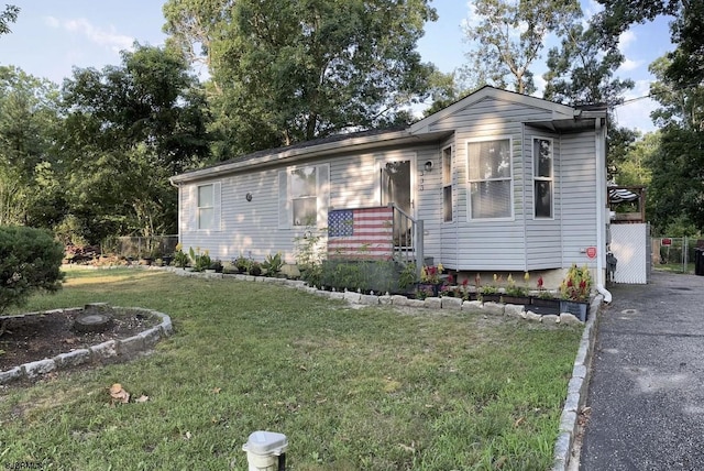 single story home with driveway and a front lawn