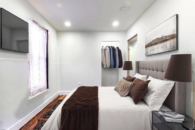 bedroom with baseboards, wood finished floors, and recessed lighting