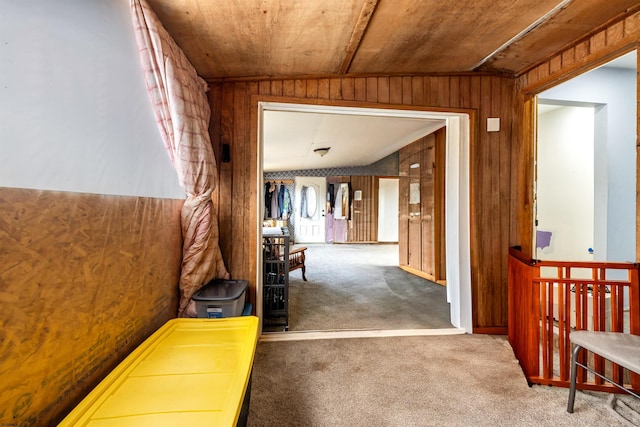 corridor with lofted ceiling, carpet floors, wooden ceiling, and wooden walls