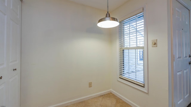 unfurnished dining area featuring light tile patterned floors and baseboards