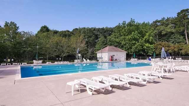 community pool with a patio and fence