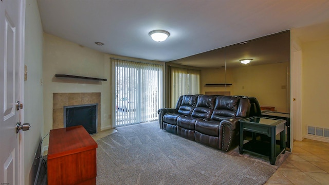 living area featuring visible vents, a fireplace, baseboards, and light tile patterned floors