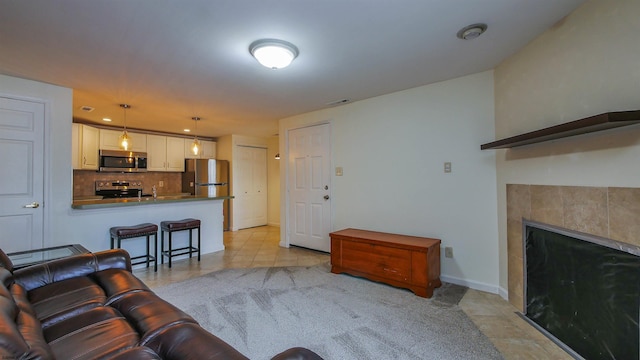 living area featuring visible vents, a fireplace, baseboards, and light tile patterned floors