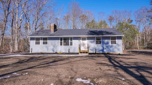 single story home with entry steps and a chimney