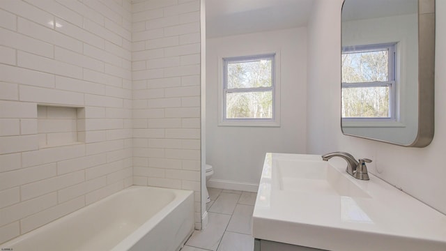 bathroom with toilet, vanity, a wealth of natural light, and baseboards