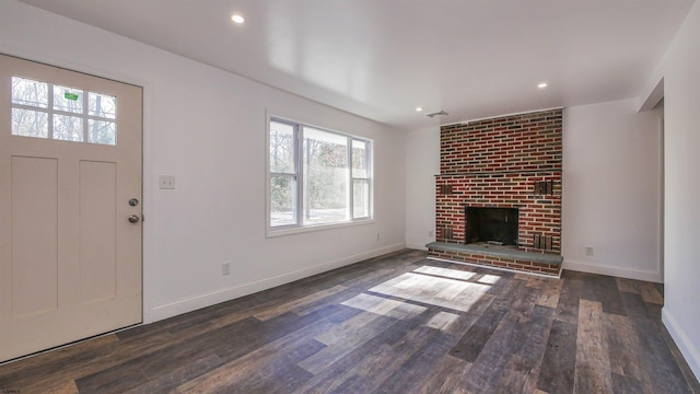 unfurnished living room featuring a fireplace, dark wood finished floors, and baseboards