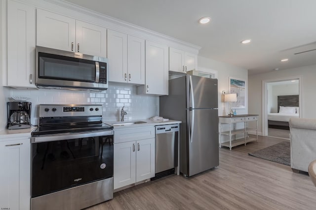 kitchen featuring white cabinetry, stainless steel appliances, and light countertops