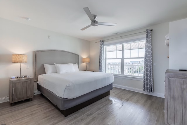 bedroom featuring ceiling fan, wood finished floors, and baseboards