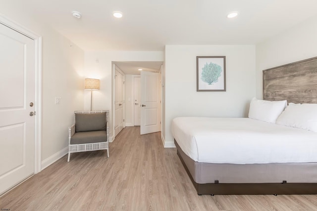 bedroom with baseboards, recessed lighting, and light wood-style floors