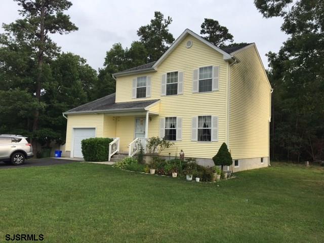 view of front of house with aphalt driveway, an attached garage, and a front yard