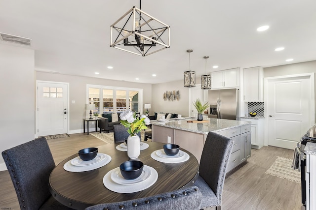 dining room with light wood-type flooring, an inviting chandelier, visible vents, and recessed lighting