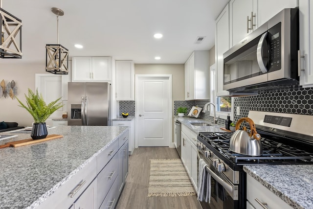 kitchen featuring visible vents, appliances with stainless steel finishes, a sink, and white cabinetry