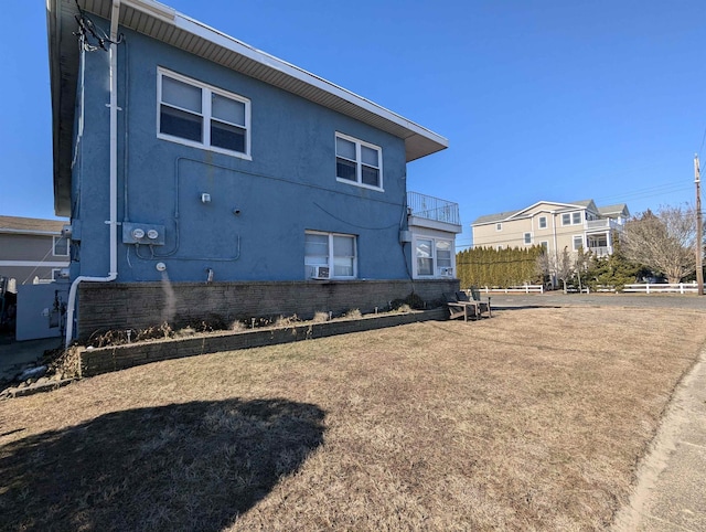 view of property exterior featuring brick siding, fence, and stucco siding