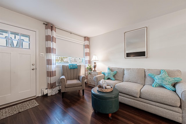 living area with a baseboard heating unit and dark wood-type flooring