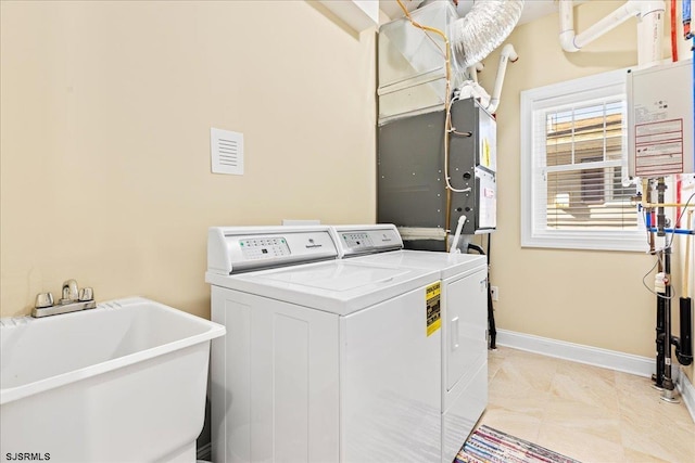 laundry room with visible vents, a sink, laundry area, independent washer and dryer, and baseboards