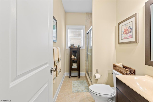 full bathroom with toilet, a shower stall, baseboards, and vanity