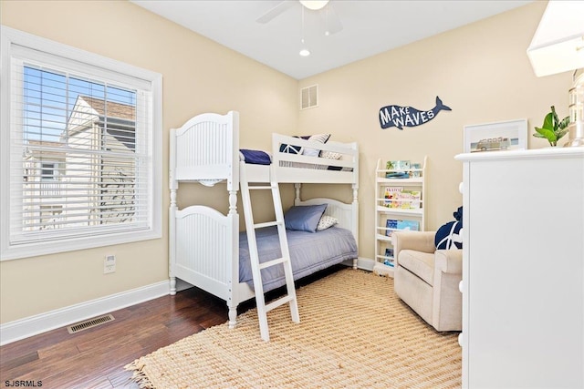 bedroom featuring visible vents, ceiling fan, baseboards, and wood finished floors