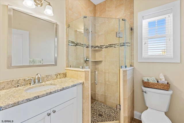 bathroom with a stall shower, vanity, and toilet