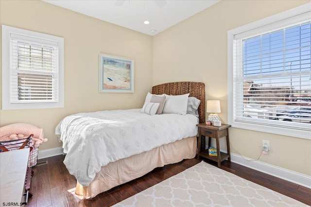 bedroom with multiple windows, baseboards, and dark wood-style flooring