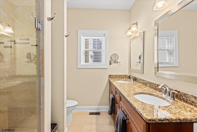 bathroom featuring toilet, a shower stall, visible vents, and a sink