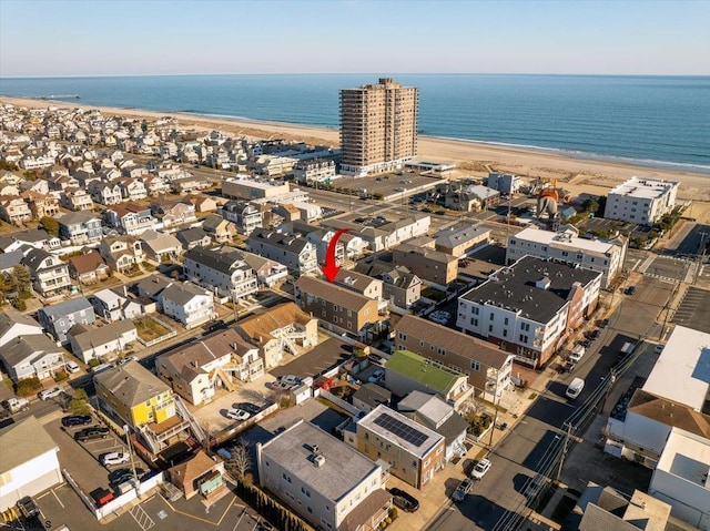 birds eye view of property featuring a beach view and a water view