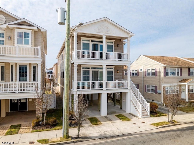 view of front of property with a balcony, driveway, and a carport