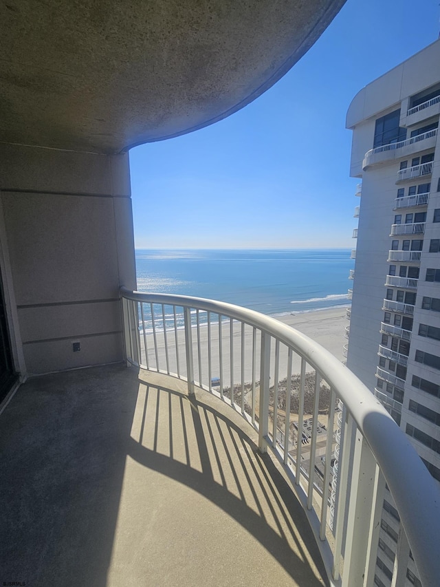 balcony with a water view and a beach view