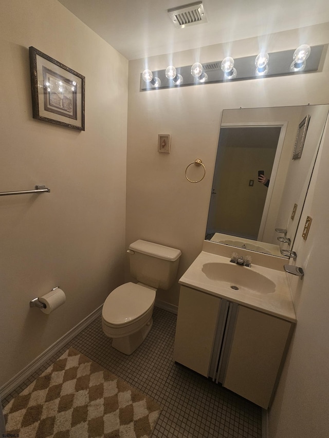 bathroom with tile patterned flooring, toilet, vanity, visible vents, and baseboards