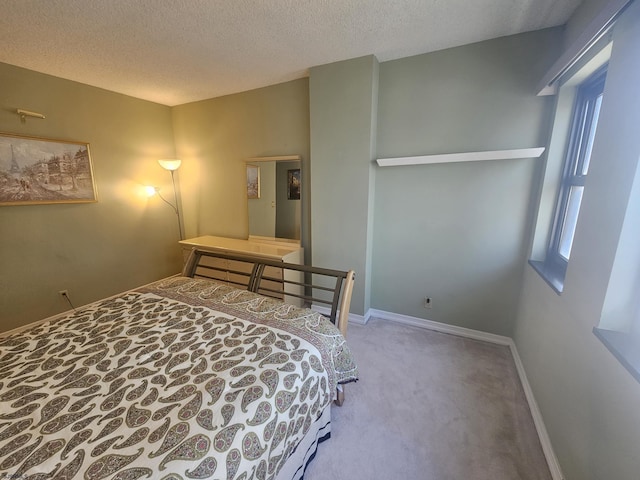 bedroom with carpet floors, baseboards, and a textured ceiling