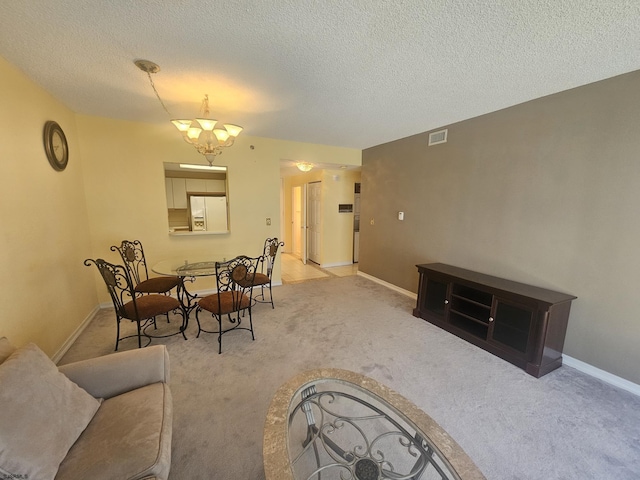 dining area featuring an inviting chandelier, baseboards, a textured ceiling, and light colored carpet