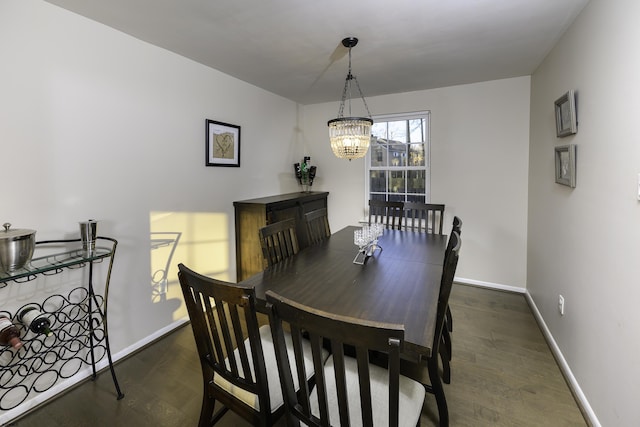 dining area with a chandelier, dark wood finished floors, and baseboards