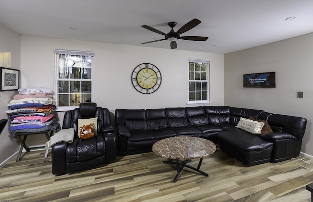 living room featuring ceiling fan, baseboards, and wood finished floors