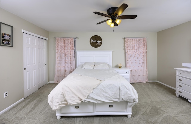 bedroom featuring a ceiling fan, a closet, light colored carpet, and baseboards