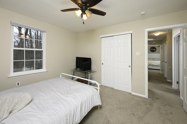 bedroom with carpet, a closet, a ceiling fan, attic access, and baseboards