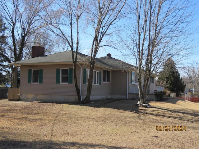 view of property exterior with a yard and a chimney