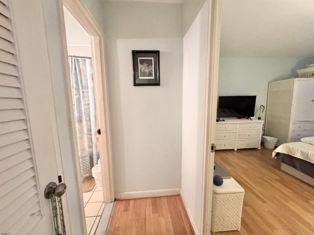 hall featuring baseboards and wood finished floors