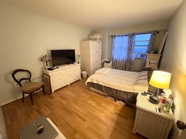 bedroom featuring baseboards and wood finished floors