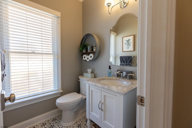 bathroom with baseboards, vanity, and toilet