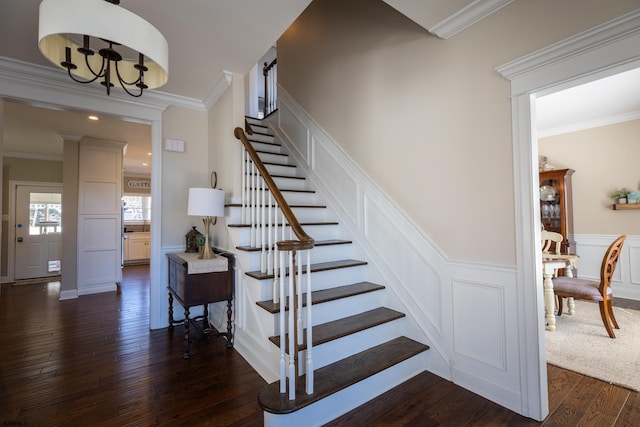 staircase featuring a wainscoted wall, wood-type flooring, a decorative wall, and crown molding