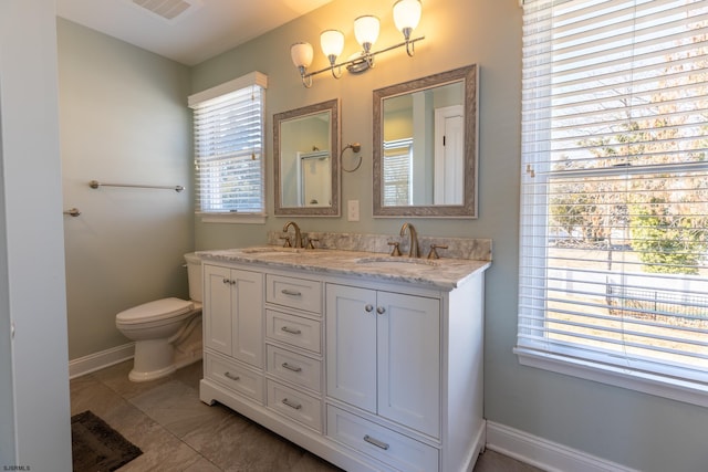 full bathroom featuring toilet, double vanity, visible vents, and a sink