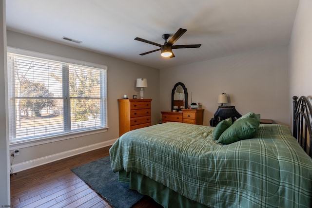 bedroom featuring dark wood-style floors, ceiling fan, visible vents, and baseboards