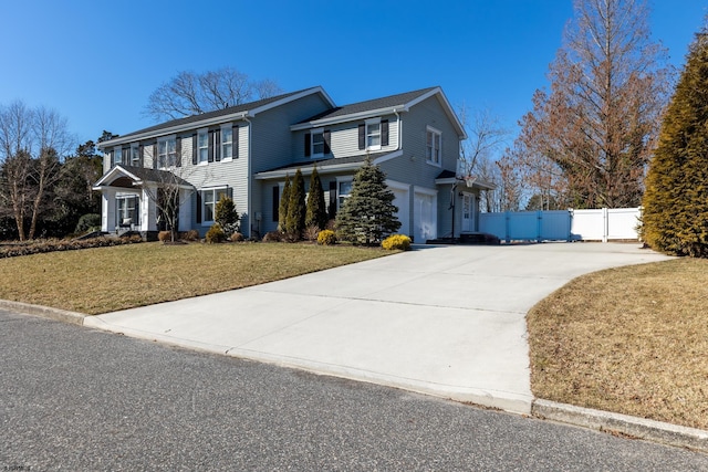 view of front facade with a gate, fence, driveway, and a front lawn