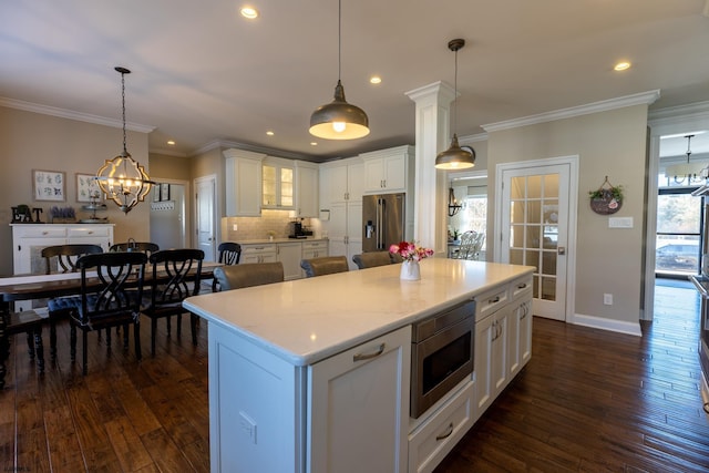 kitchen with stainless steel appliances, white cabinets, and dark wood finished floors